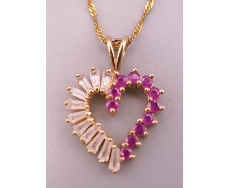 A 10 K gold, ruby and white stone heart shaped pendant on a 9 ct gold chain.  Pendant 2.5 cm high including suspension loop, 
