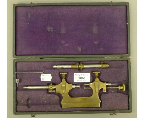 A cased antique brass clock maker's tool. The case 27.5 cm long.