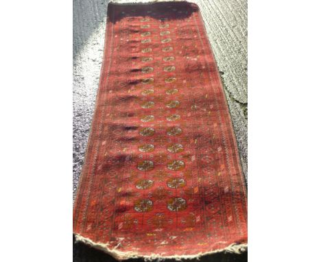 A red ground wool runner.  80 x 265 cm.
