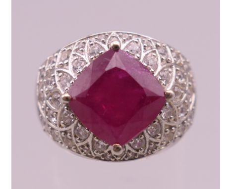 A silver, red stone and cubic zirconia ring.  Ring size Q/R.
