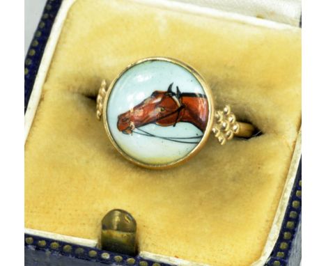 A GOLD RING WITH ASSOCIATED ENAMEL ROUNDEL OF THE HEAD OF A HORSE, MARKED 9K, 2.7G GROSS 