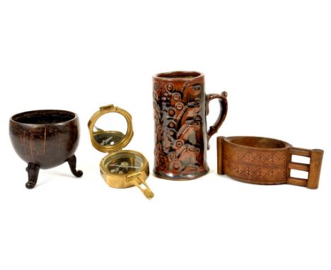 A SCANDINAVIAN CARVED SOFTWOOD DRINKING VESSEL, A COCONUT CUP ON THREE SCROLL FEET, A STUDIO POTTERY CARVED STONEWARE MUG WIT