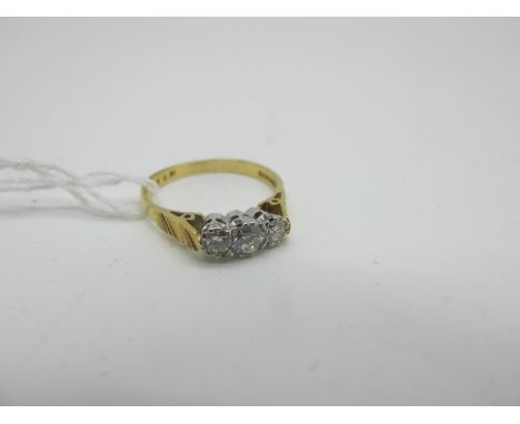 An 18ct Gold Three Stone Diamond Ring, the brilliant cut stones claw set between textured shoulders (finger size K) (2grams).