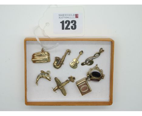 A Novelty 9ct Gold Articulated Bi-Plane Charm Pendant, together with a novelty 9ct gold lighter charm pendant, a 9ct gold sax