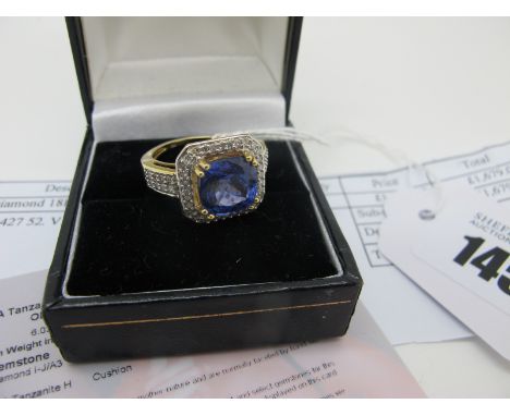 A Modern 18ct Gold Lorique Tanzanite and Diamond Cluster Ring, the cushion cut tanzanite corner claw set, within square borde
