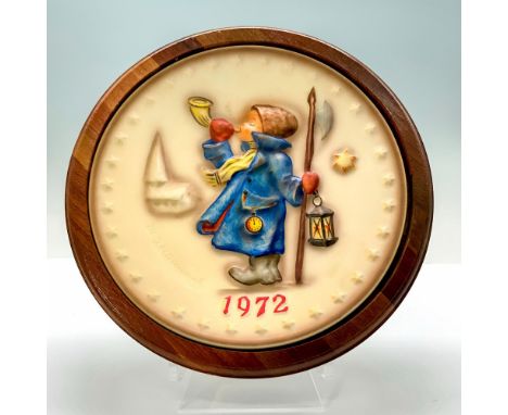 A wall plate showing a high relief scene of a young boy dressed in a blue jacket blowing a horn. Goebel Hummel backstamp. Iss