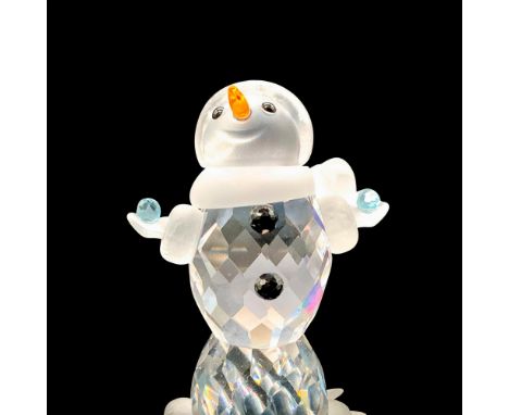 A clear crystal figure of a snowman with his arms wide open holding two snowballs that are made of light blue crystals. An or