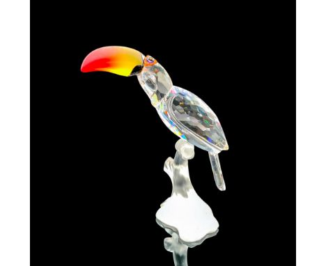 Depicts a clear body toucan with a red and yellow blended beak standing on a fogged crystal branch. Swarovski backstamp. This