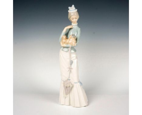 Glazed figure of a young woman holding a Pekingese. Lladro backstamp. This item has its original box: 17.5"L x 7"W x 6.75"H. 