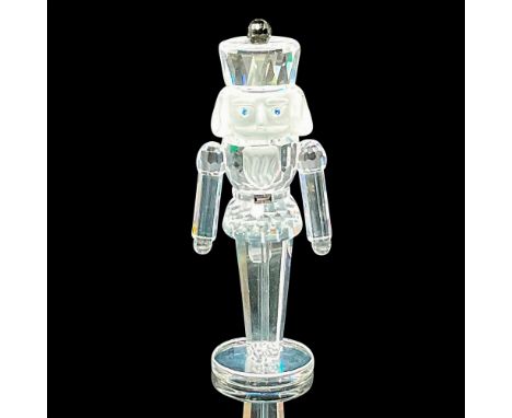 Part of the 'Exquisite Accents' theme. A clear nutcracker with frosted face, blue crystal eyes, and black crystal on his hat 