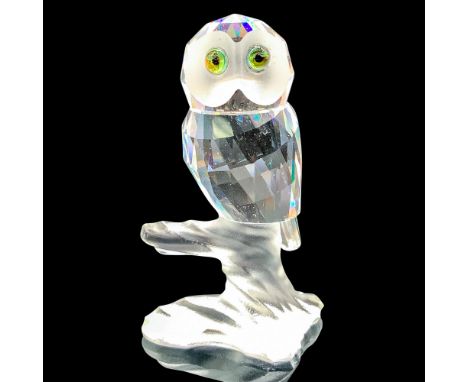 Depicts a clear crystal owl with cantaloupe-colored eyes sitting on top of a fogged crystal branch. Swarovski backstamp. This