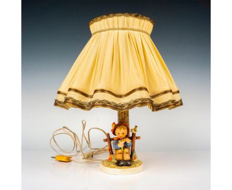 Electric figural lamps hand painted in matte finish muddled as a young boy seated holding a daisy. Includes original lamp sha