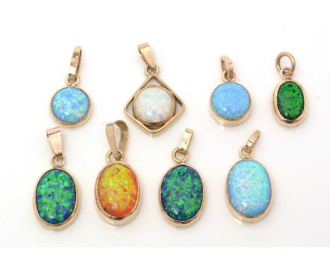 Eight synthetic opal pendants, each in 9ct yellow gold mounts, emulating white, black and fire opal, 24.8g gross. 