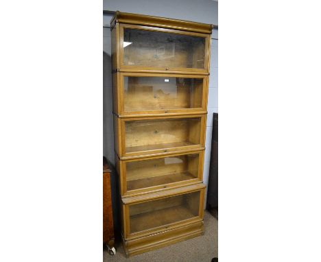 Globe Wernicke: a light oak five-tier sectional bookcase, with glazed dust covers, 87 x 210cms high.