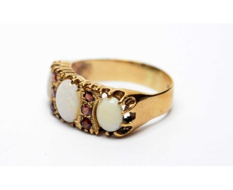 An opal and garnet ring, the three oval opal cabochons parted by garnets, on 9ct yellow gold shank, ring size Q, 3.4g gross. 