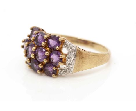 An amethyst and diamond ring, set with ten circular facet cut amethysts flanked by diamond shoulders, on 9ct yellow gold shan