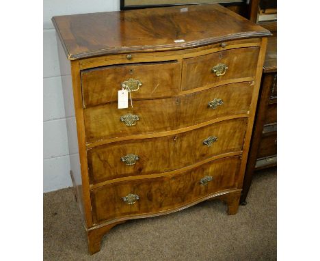A walnut serpentine dressing chest in the Georgian style, with brushing slide above two short and two long graduated drawers,