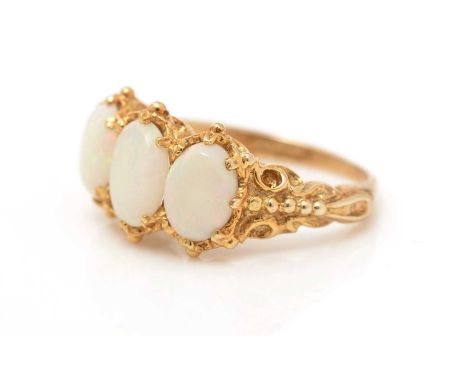 A white opal ring, the three opal cabochons in textured 9ct yellow gold mount and shank, ring size K, 3.5g gross. 