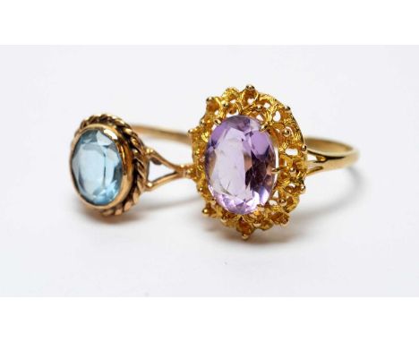 An amethyst ring in nest pattern mount, and a blue stone (probably topaz) ring, both in 9ct yellow gold mounts and shanks, 6.