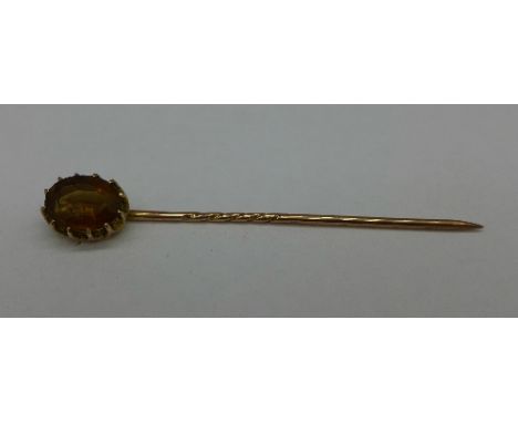 A yellow metal and orange stone stick pin, 1.5g