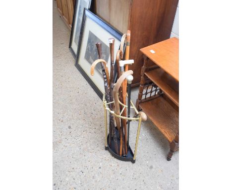BRASS AND IRON STICK STAND CONTAINING AN ASSORTMENT OF VARIOUS WALKING STICKS