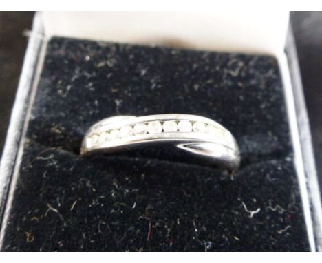 9 ct white gold ring channel set with ten white stones, probably white sapphires. Size U.