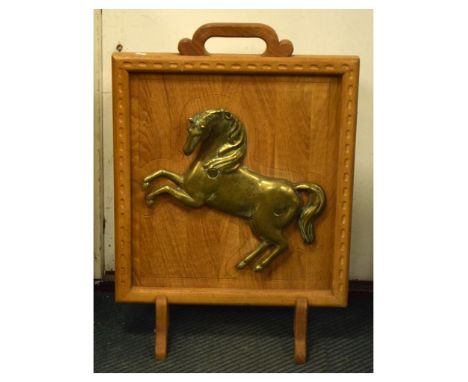Oak firescreen fitted a relief cast brass prancing horse, 73.5cm high  
