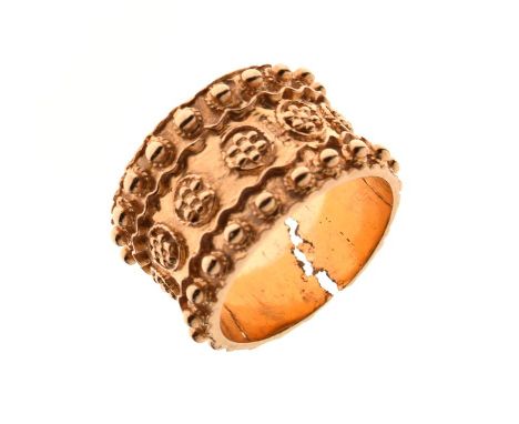 Unmarked yellow metal band ring of broad design with band of flowerheads within studded borders, size R, 9.8g approx (at faul