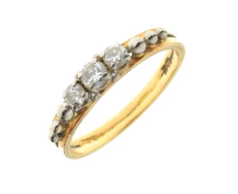 Yellow metal and three stone diamond ring, the stones set between silvered ball ornaments, shank stamped 18ct, size N, 3.3g g