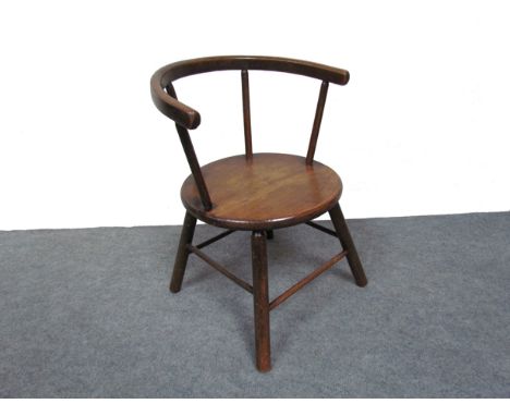 A child's wooden stick-back tub chair with penny seat