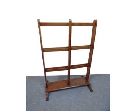 A 19th Century mahogany folding nine bar towel rail on a shelf base and sledge feet