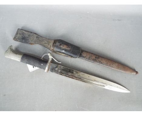 A German dress bayonet with 9 3/4" blade with WKC makers mark, black composite grip, with scabbard.Condition Report: No appar