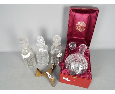 Four decanters, two with ceramic bottle labels (whisky and gin), to include a boxed La Talbooth 'Passport Decanter and stand.