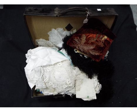 A vintage suitcase containing a quantity of vintage linen.