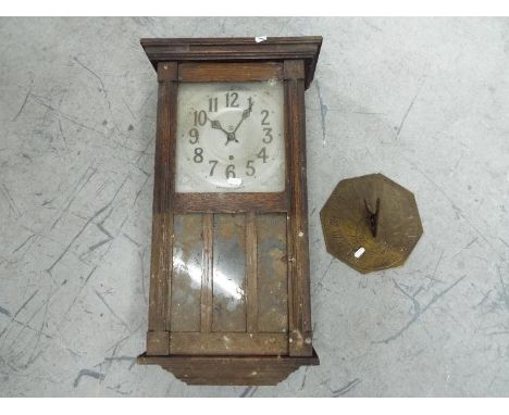 An oak cased wall clock with key and pendulum and brass sundial. [2]