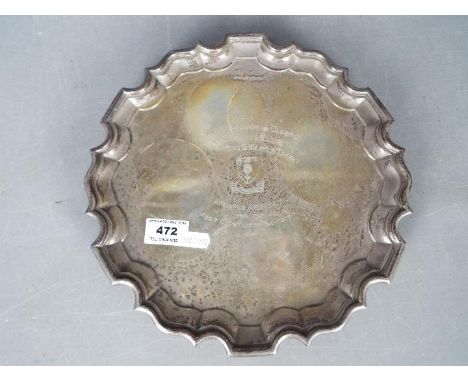 A George VI hallmarked silver salver or card tray of scalloped outline, raised on tripod scrolled supports, which has been us