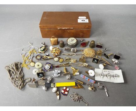 A copper box with contents including cufflinks, enamel badges, costume jewellery, dress studs and similar.