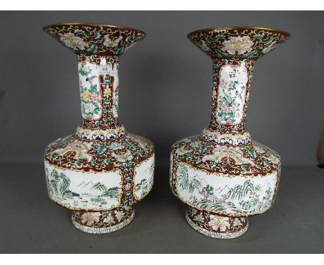 A large pair of Chinese enamel vases decorated to the body with panels of landscape scenes, birds and flowers to the neck set