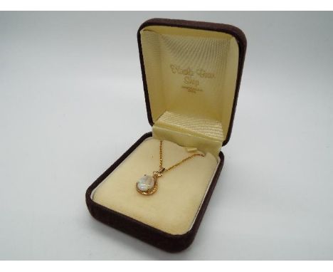 A 9ct gold and opal cabochon pendant, stamped 375, on yellow base metal chain, approximately 1.5 gram pendant weight.