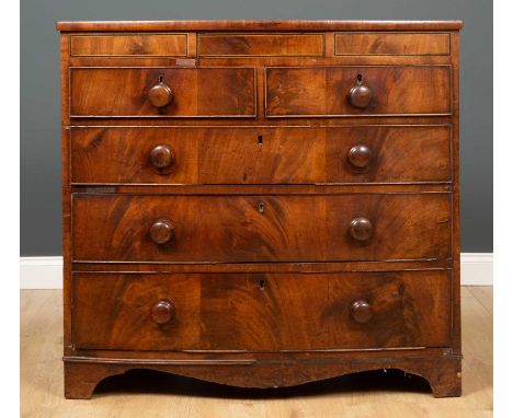 A Victorian mahogany bow fronted chest of two short over three long drawers, the frieze top with ebonised and satinwood inlai