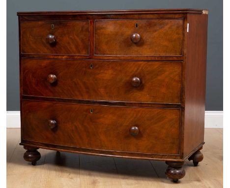 An early Victorian mahogany bow front chest of two short and two long drawers with turned knob handles, raised on turned bun 