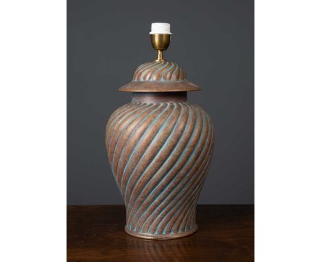 A pottery table lamp with twisted decoration to the body and gilt painted, formed as a lidded urn, 36cm high excluding fittin