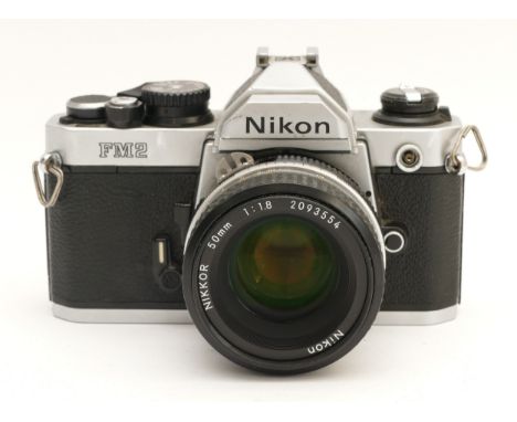 A Nikon FM2 film camera, with a Nikon f/1.8 50mm lens.