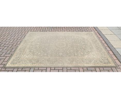 A large Persian style machine woven wool rug, circa late 20th century, having central patterned motif with floral border on a
