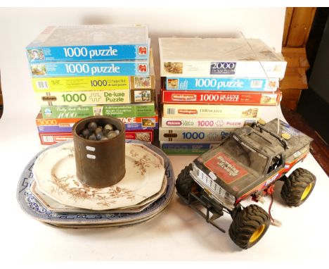 A collection of over 15 boxed jigsaw puzzles, together with a remote control model car and a quantity of glass marbles.