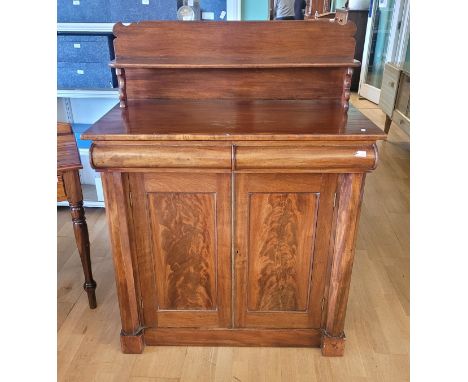 A Victorian mahogany chiffonier, the upper section having a shelf supported by tapered turned columns, above two long drawers