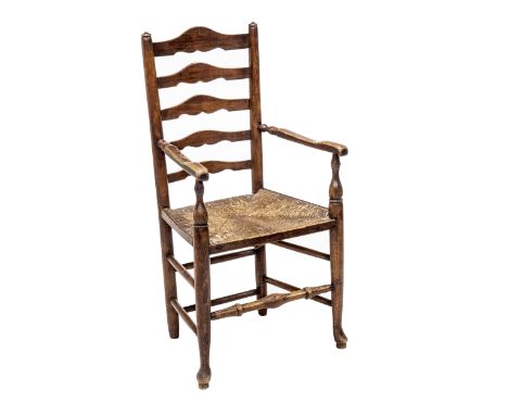 AN EARLY 19th CENTURY ELM AND OAK LANCASHIRE LADDER BACK OPEN ARMCHAIR, the back over a rush seat flanked by arms supported b