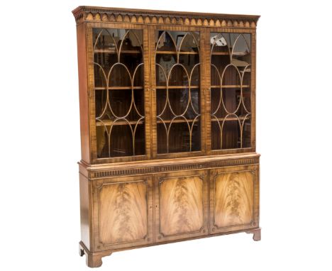 A MAHOGANY GLAZED BOOKCASE CABINET IN GEORGE III STYLE, Bevan Funnell, the upper section with a dentilled and pendant carved 