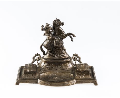 A LATE 19th CENTURY SPELTER DESK STANDISH, cast with the mounted figure of a cowboy with whip and gun above a well flanked by