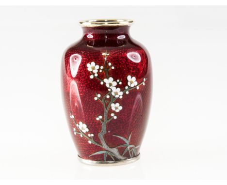 A SMALL JAPANESE RED ENAMEL VASE, of shouldered form, painted with a blossoming tree against a worked enamel ground decorated